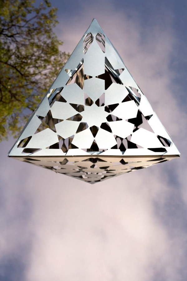 Tetraedro sobre espejo. Esta es una variante de estrellas de 9-12 en un tetraedro. En este caso he jugado con espacio lleno y vacío. Realizado con papel de color gris. Los huecos se iluminan y emiten luz cuando se ilumina desde dentro.  